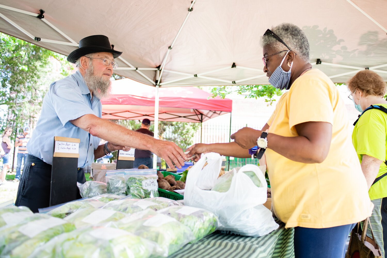 Marvin Metzger with Berry Hill Farm helps customer Alma Moody during the Fort Wayne's Farmers Market at McCulloch Park on Saturday June 19, 2021.