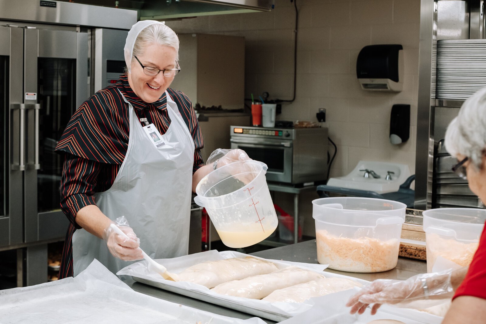 Landes's staff Judith Brovont, left, and Peggy Selleck prepare sausage bread for lunch at Manchester Junior-Senior High School, which features local pork.