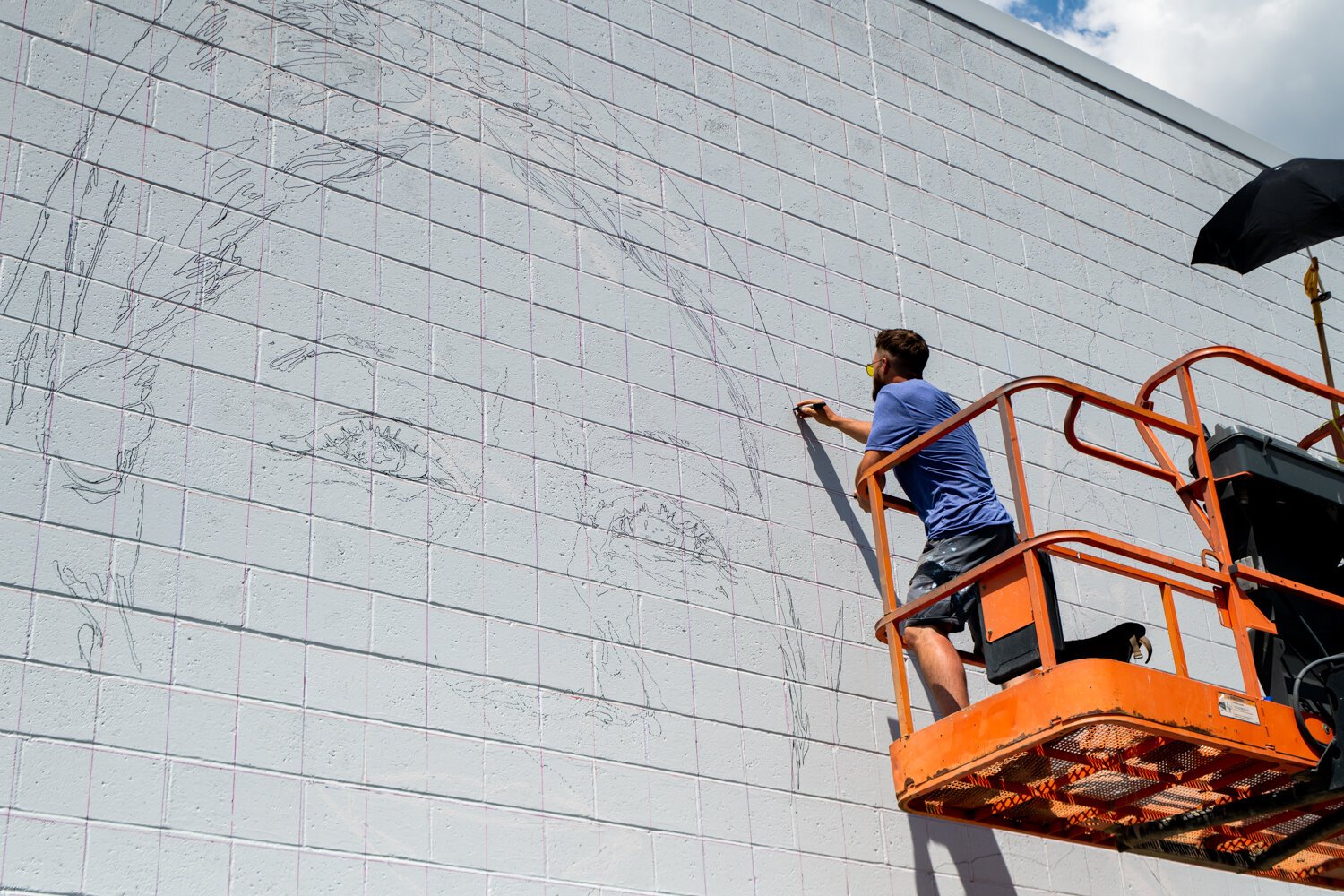 Muralist Mitchell Egly works on the Southwest Faces of the Fort mural at 1818 Bluffton Rd.