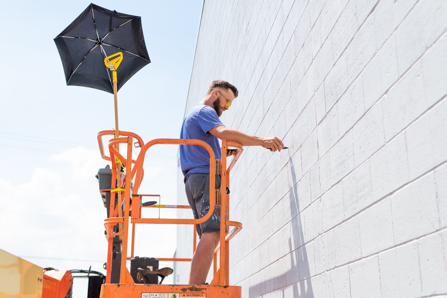 Muralist Mitchell Egly works on the Southwest Faces of the Fort mural at 1818 Bluffton Rd.