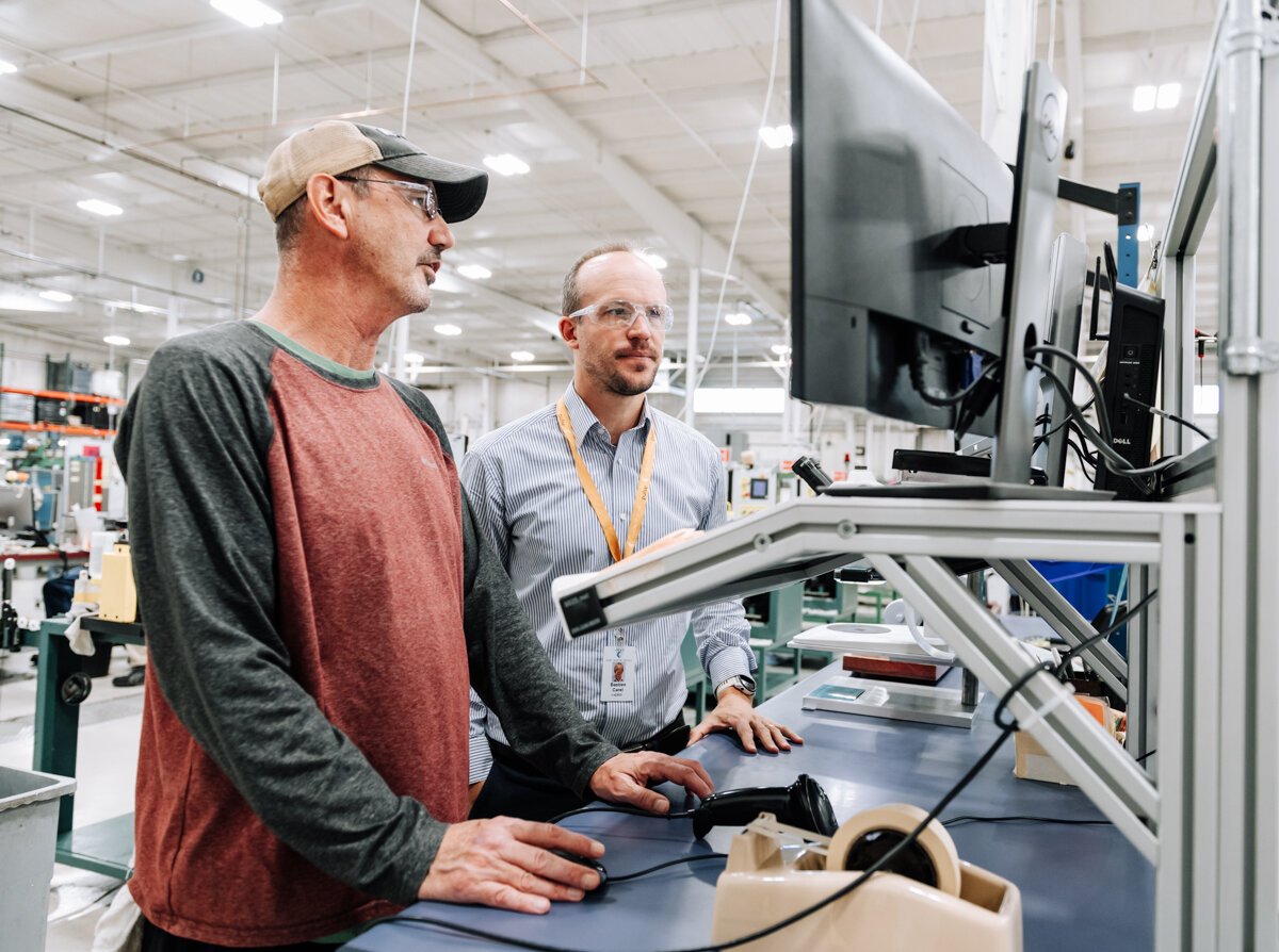 Bastien Carel, Advanced Manufacturing Manager, right, works with Brad Peffley, Wire Drawer, using new technology that provides real-time & historical data via a web interface that collects data from 70-80 machines.