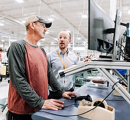 Bastien Carel, Advanced Manufacturing Manager, right, works with Brad Peffley, Wire Drawer, using new technology that provides real-time & historical data via a web interface that collects data from 70-80 machines.