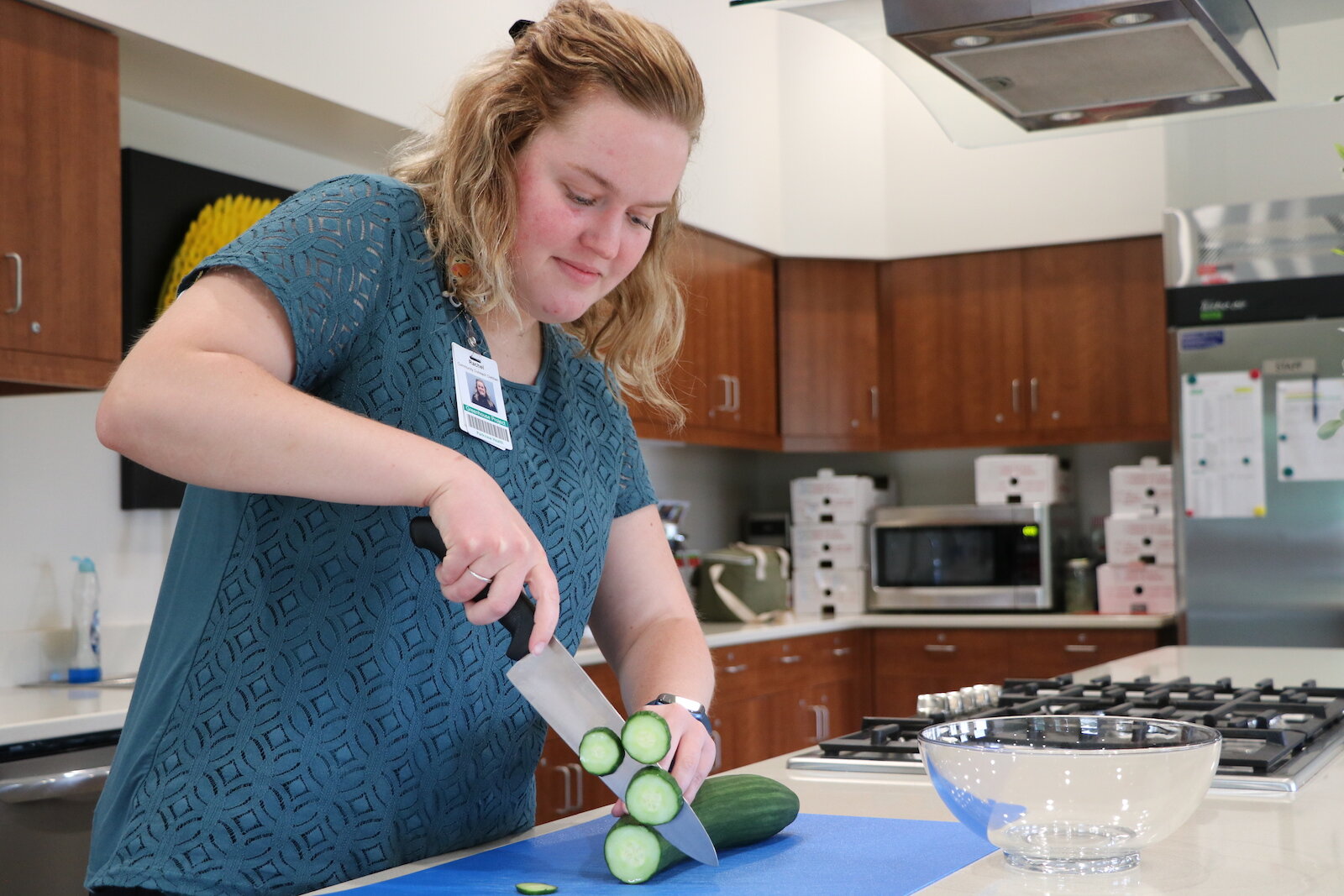 Rachel Stohlman, a community outreach dietitian at the Parkview Community Greenhouse and Learning Kitchen, slices up a cucumber. 