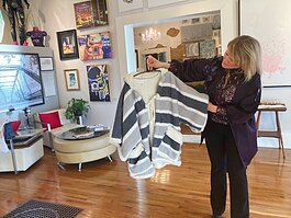 Kristina Wiley of Gallery K shows some of the fashion in shop, including specialty apparel by ShareChic Boutique.