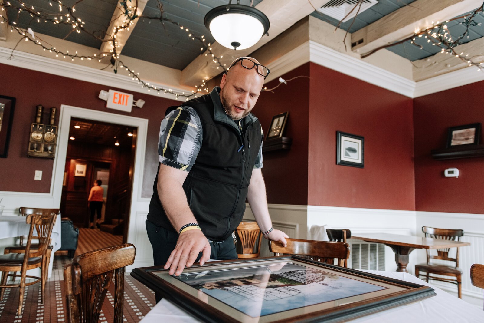 Grant Richardson, Dining Room Manager, shows off pictures at Don Hall's Old Gas House, 305 E. Superior.