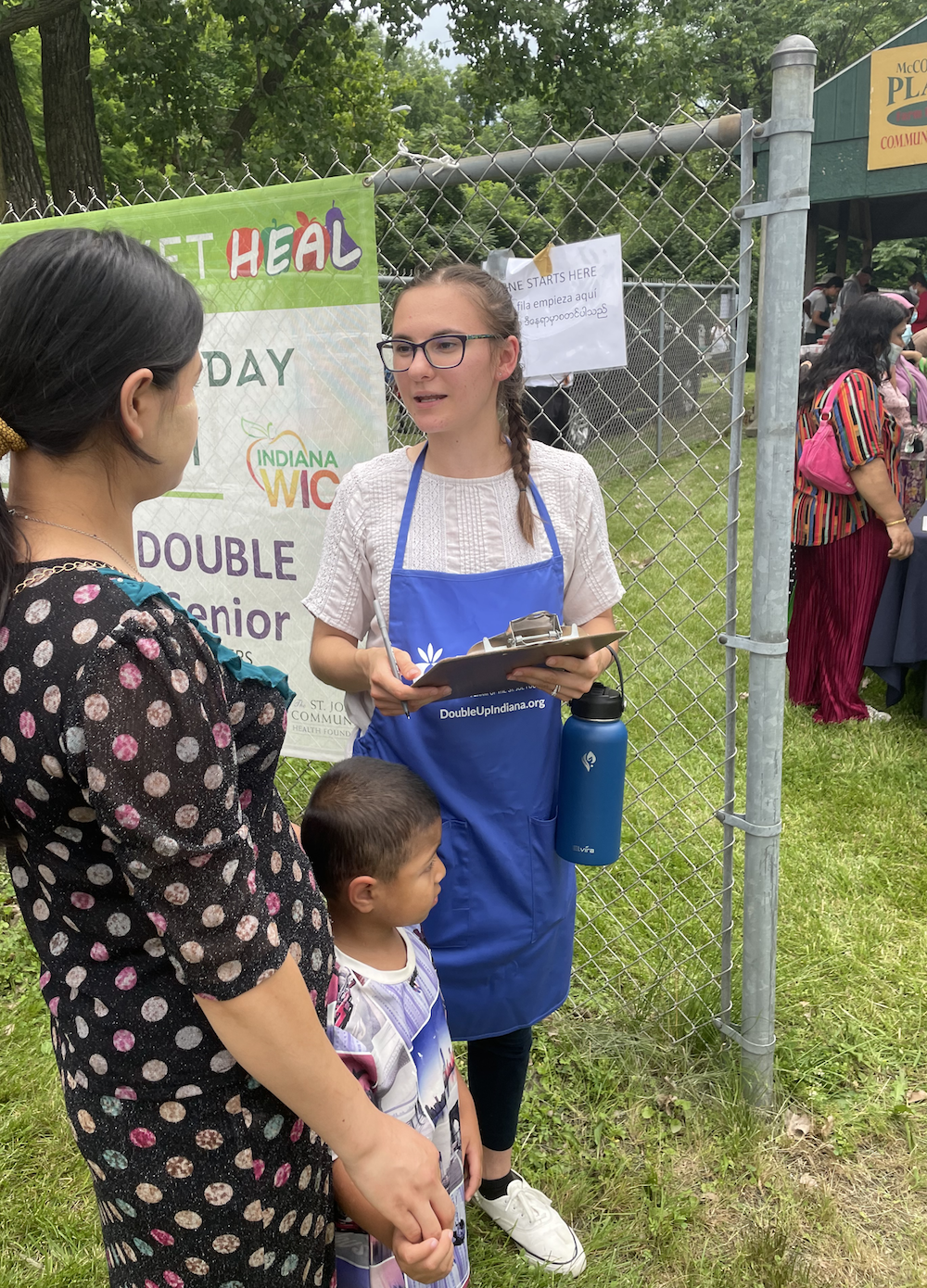 A volunteer, Felician, welcomes guests at the HEAL Market at McCormick Place Apartments.