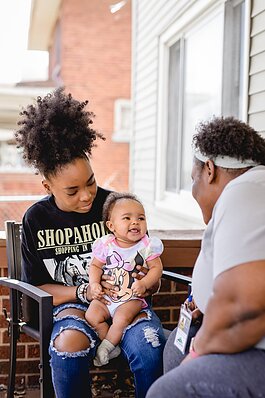 Home visits are a key part of Healthier Moms and Babies' programs. Here a home visitor chats with a mom and her baby.