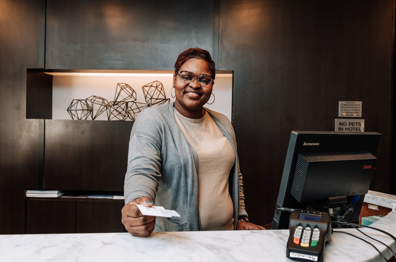 Letha Hill, Front Desk Attendant, hands out a key card during her shift at Courtyard by Marriott in Downtown Fort Wayne.