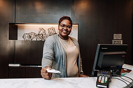 Letha Hill, Front Desk Attendant, hands out a key card during her shift at Courtyard by Marriott in Downtown Fort Wayne.