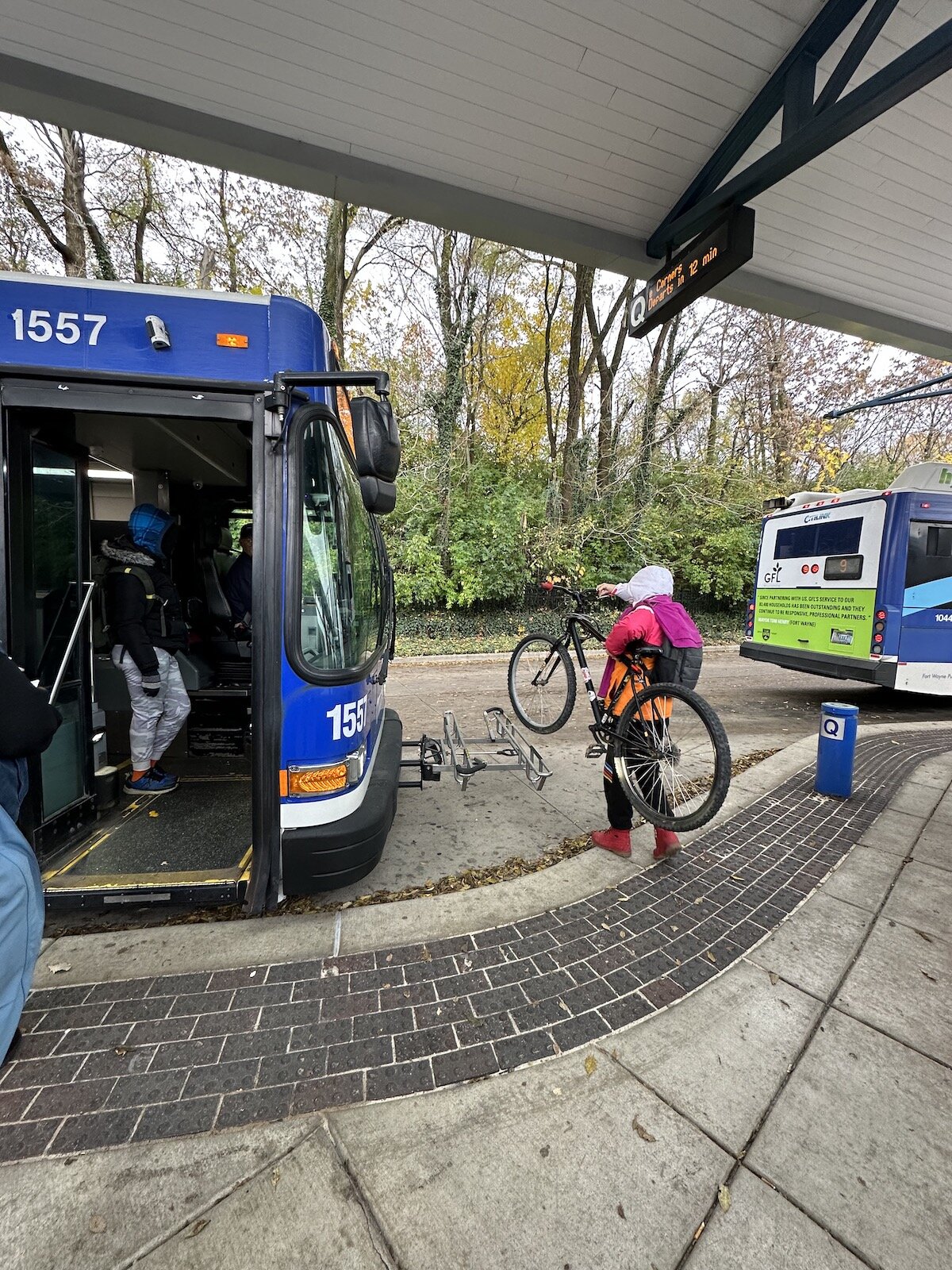 A rider places her bike on the bus' bike rack at the Central Station.
