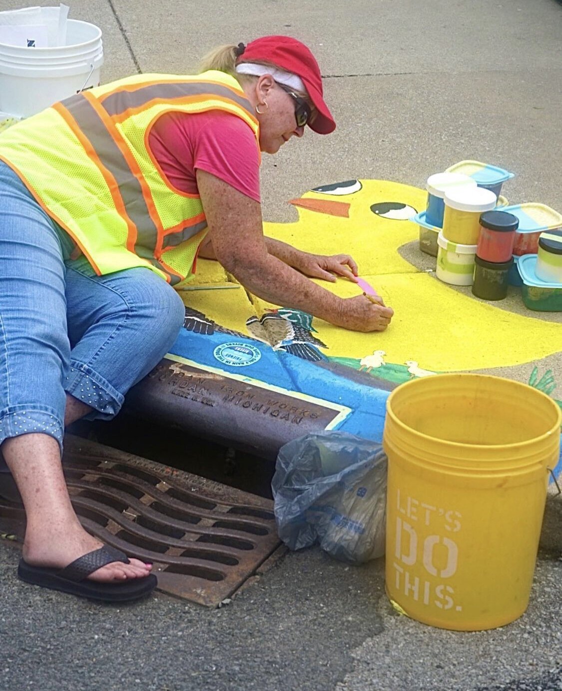 Joan Means paints a new mural on the corner of Calhoun Street and E. Masterson Avenue during Open Streets Fort Wayne.