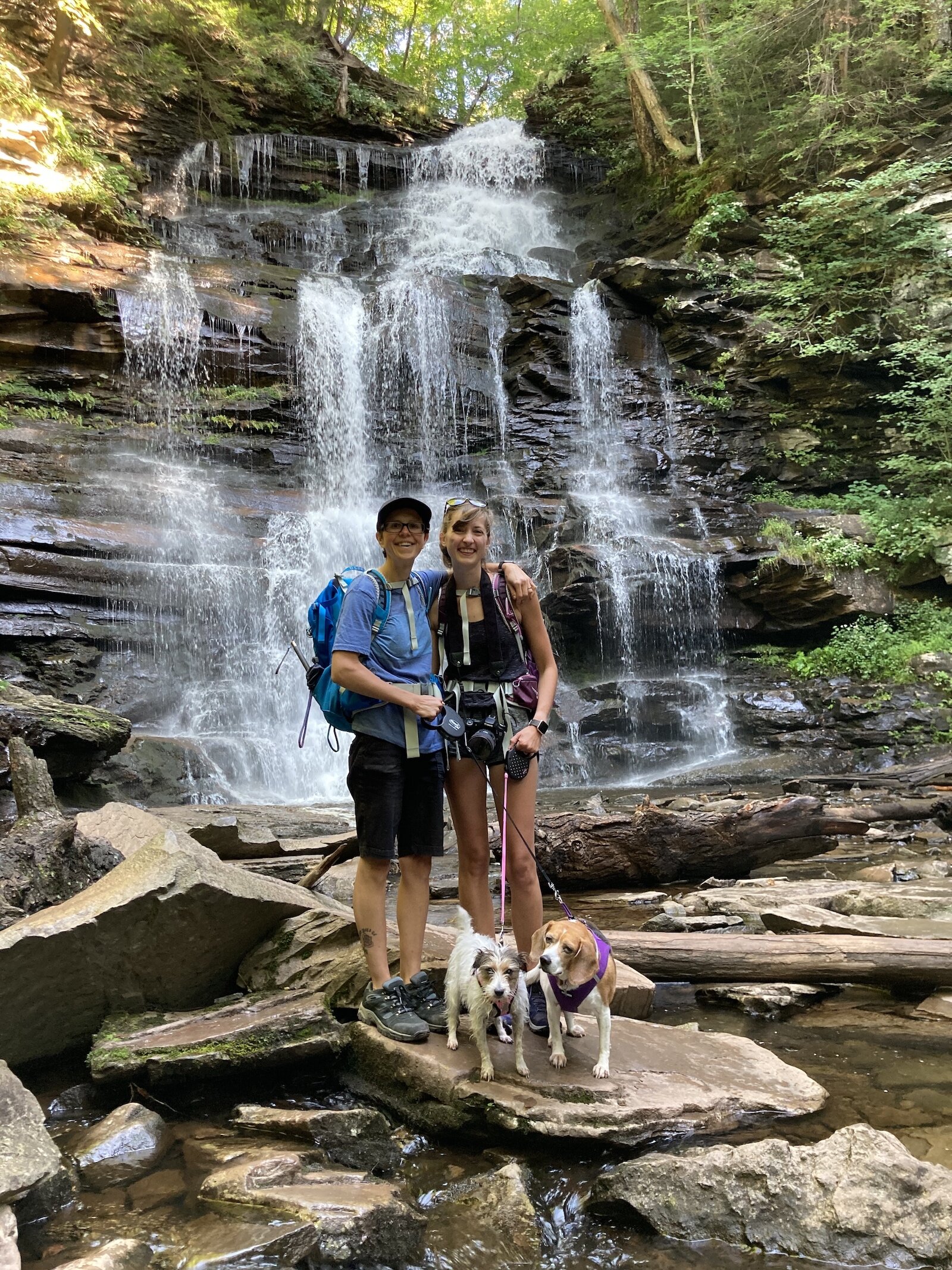 Alexys Esslinger (right) and her wife, Erica Esslinger, with their dogs, hiking in Ricketts Glen State Park in Pennsylvania. 