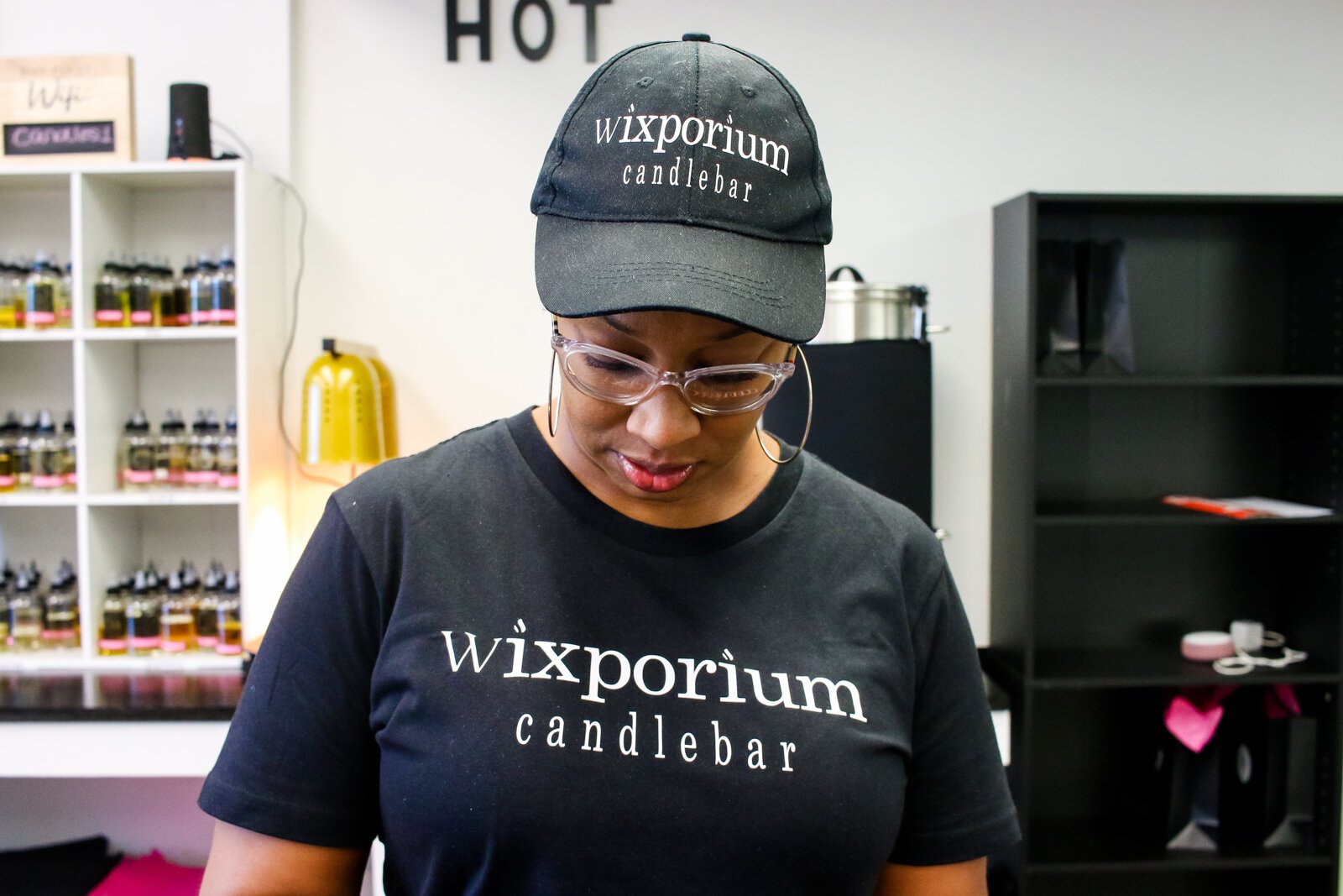 Londria Ladner, owner of Wixporium, helps customers at the candle bar.