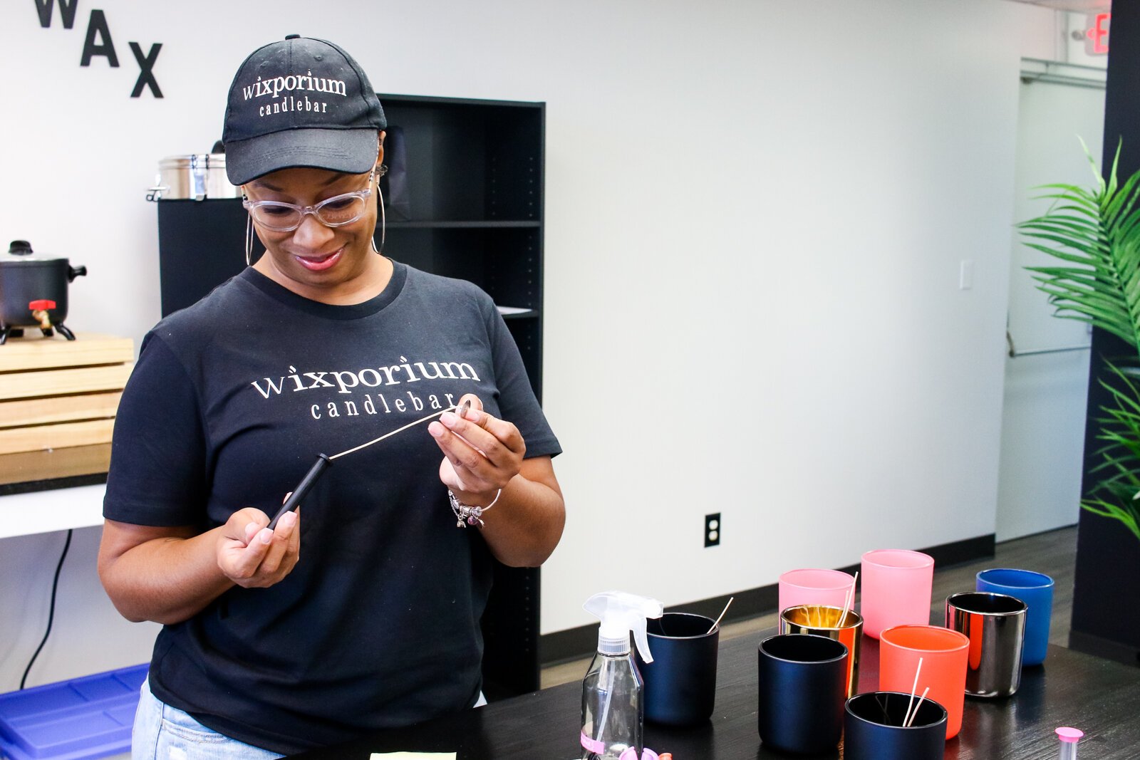 Londria Ladner, owner of Wixporium, helps customers at the candle bar.