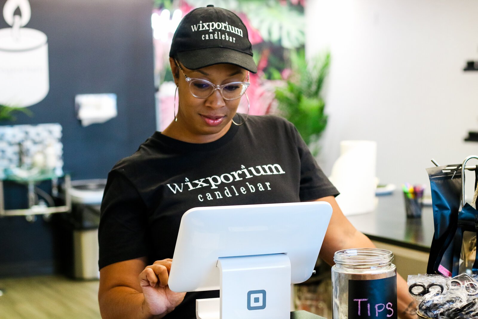 Londria Ladner, owner of Wixporium, helps customers at the candle bar.