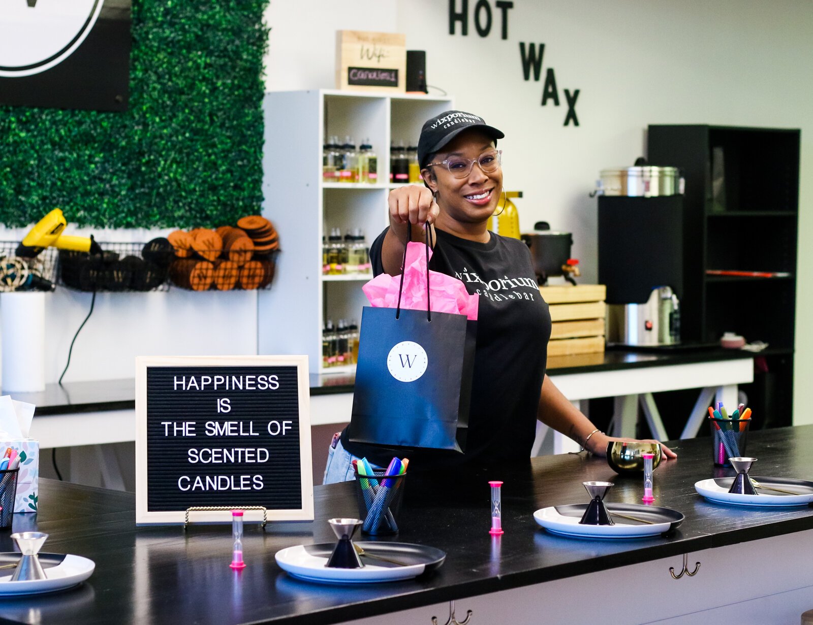 Londria Ladner, owner of Wixporium, helps customers at the candle bar.