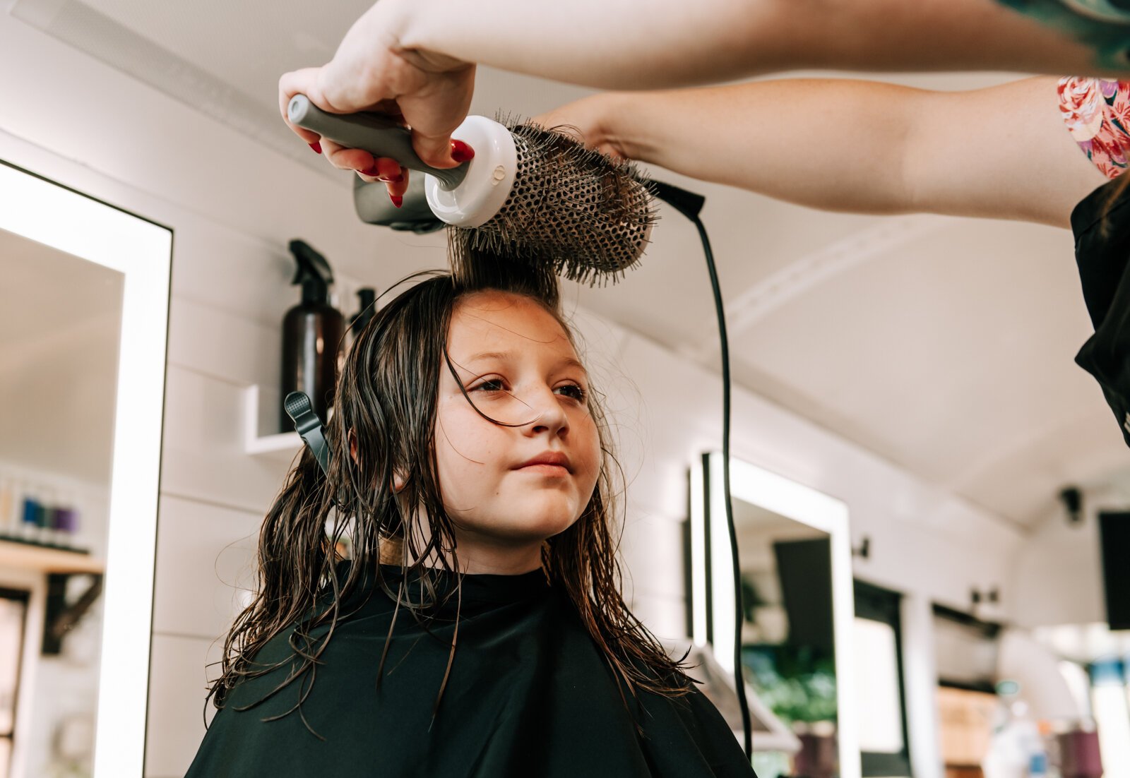 Owner Beth Morken works on giving Avyn Oliver, 10, a kid's cut, blow dry and style on the 260HairBus.