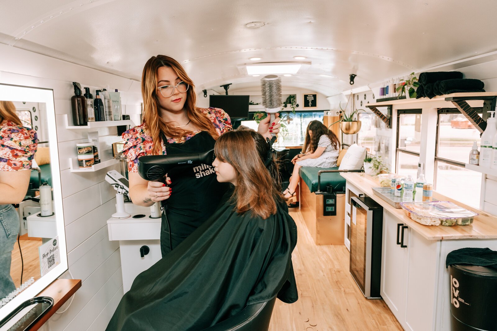 Owner Beth Morken works on giving Avyn Oliver, 10, a kid's cut, blow dry and style on the 260HairBus.