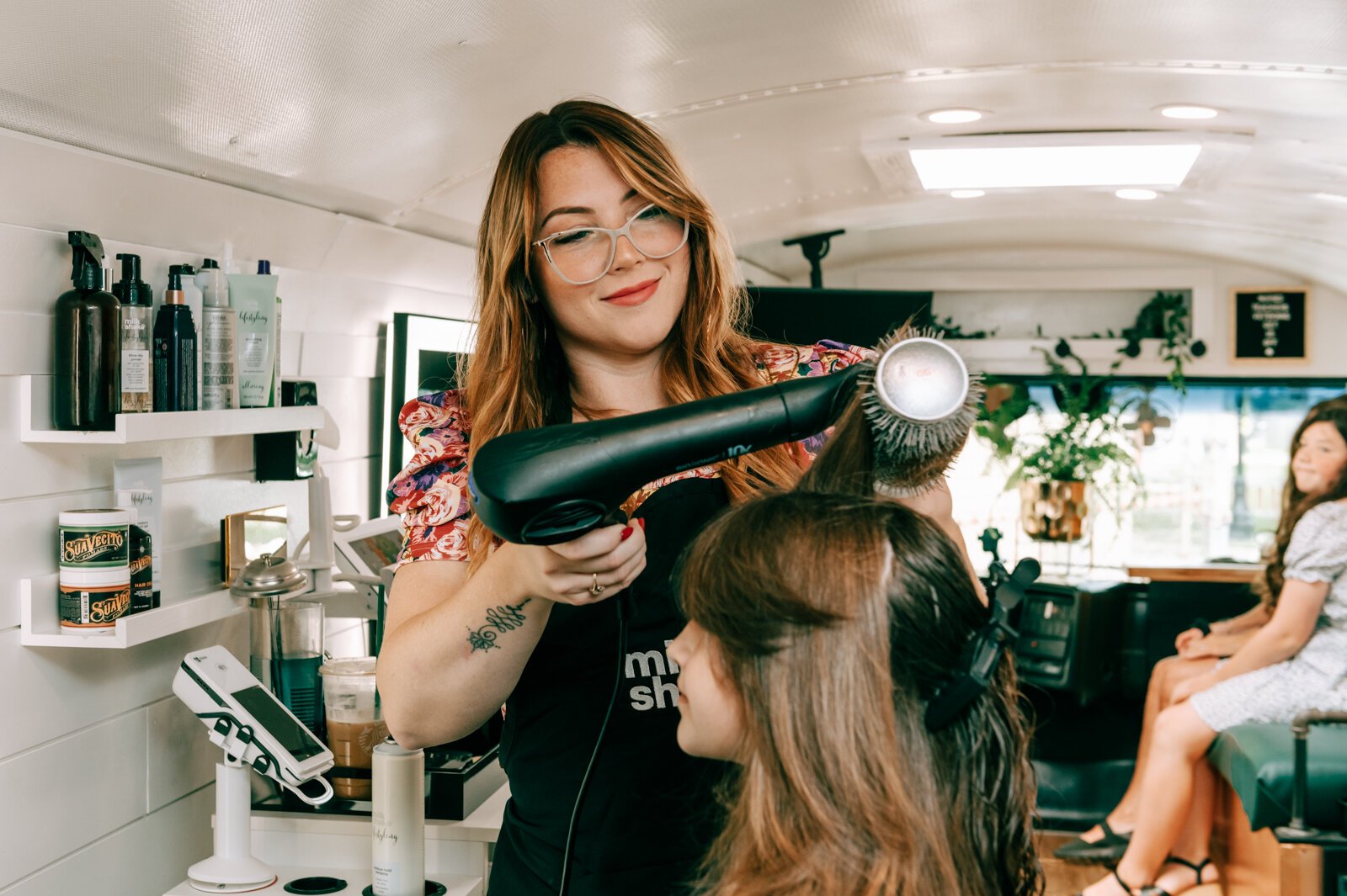 Owner Beth Morken works on giving Avyn Oliver, 10, a kid's cut, blow dry and style on the 260HairBus.