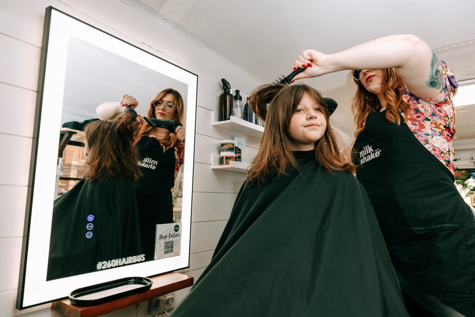 Owner Beth Morken works on giving Avyn Oliver, 10, a kid's cut, blow dry and style on the 260HairBus.