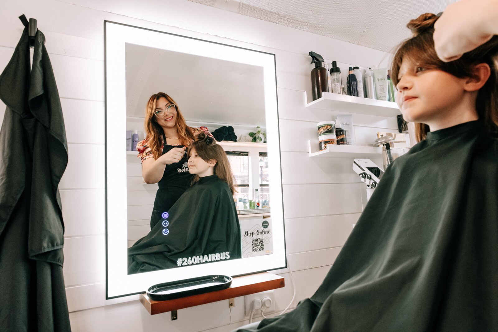 Owner Beth Morken works on giving Avyn Oliver, 10, a kid's cut, blow dry and style on the 260HairBus.