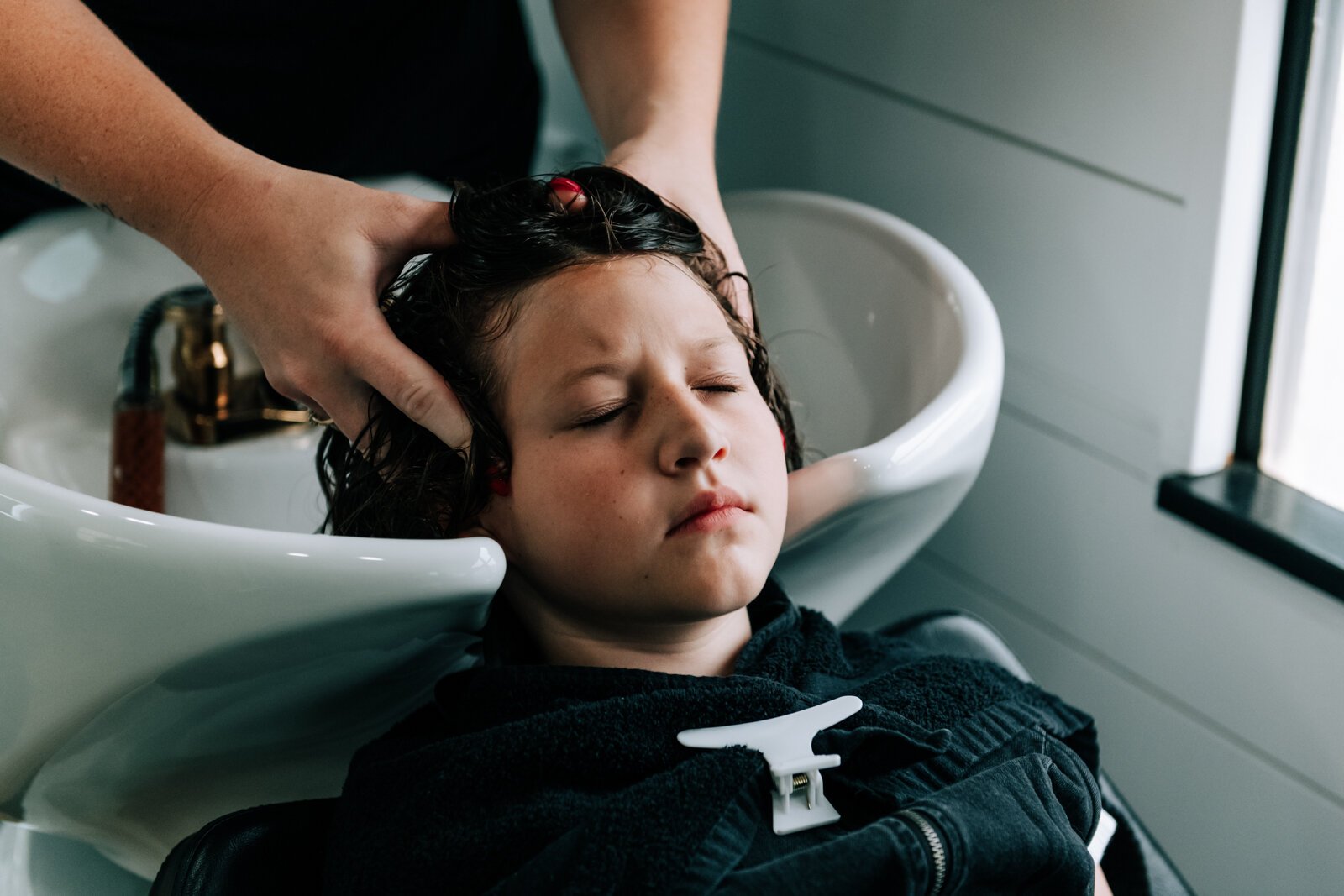 Owner Beth Morken works on giving Avyn Oliver, 10, a kid's cut, blow dry and style on the 260HairBus.