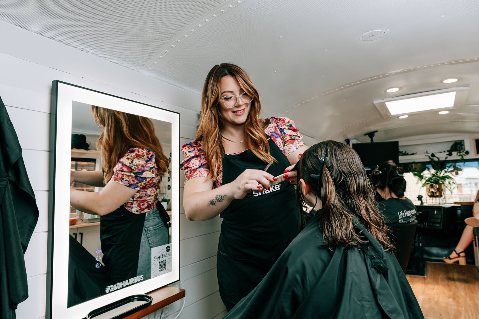 Owner Beth Morken works on giving Avyn Oliver, 10, a kid's cut, blow dry and style on the 260HairBus.