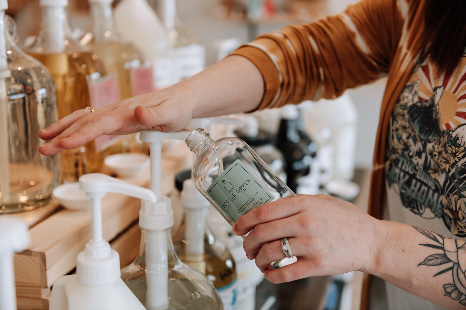  Bottle Green Refillery Owner Corinna Shoemaker refills a bottle with a lavender & lime essential oils bubble bath.