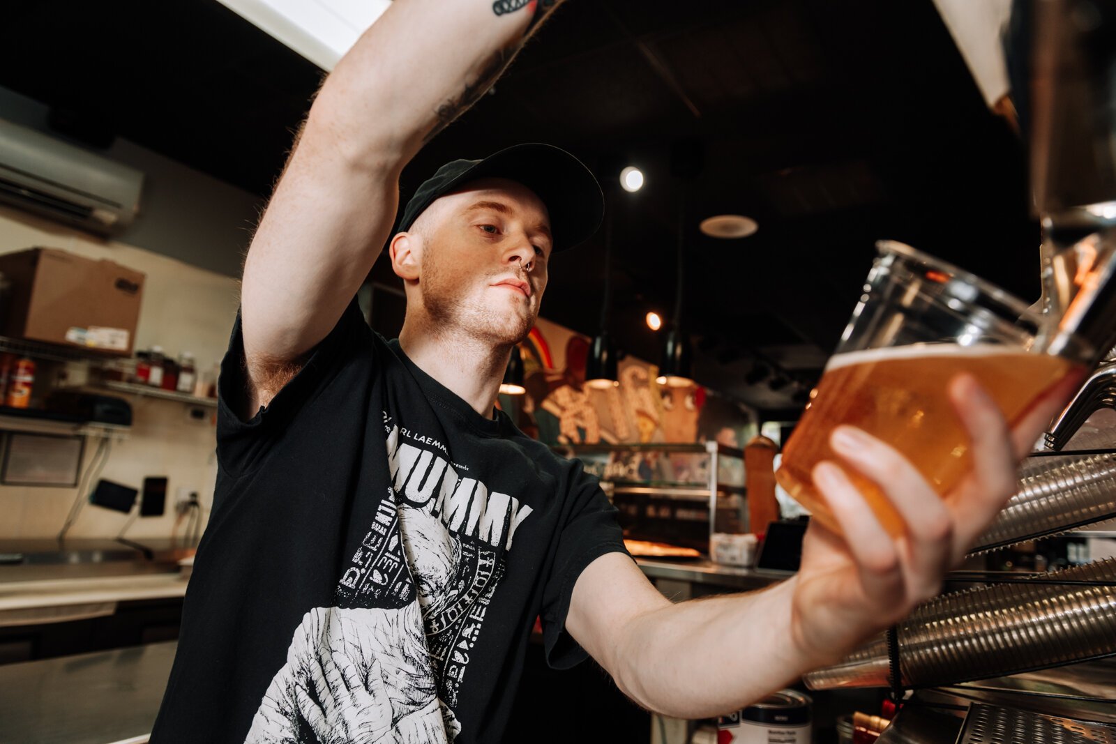 Pint & Slice Manager Tristan Wright pours a Miller Lite. Pint & Slice is one of several businesses that will participate in the Downtown DORA.