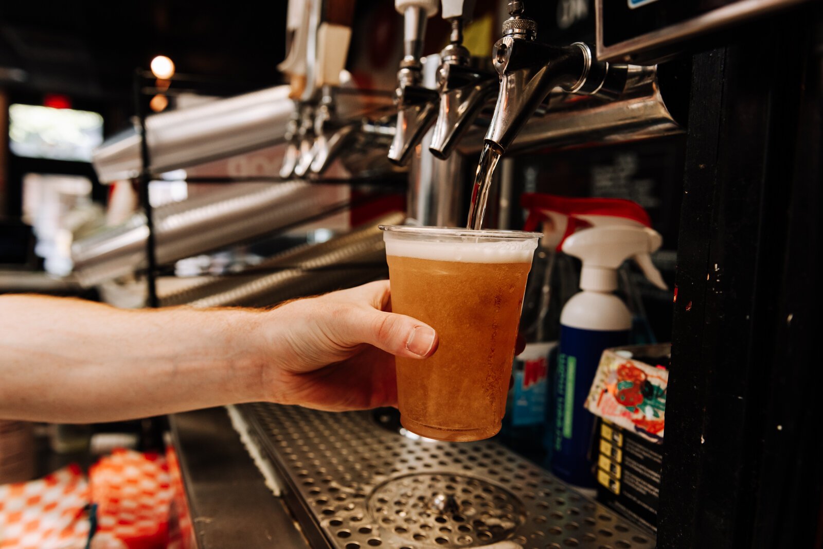 Pint & Slice Manager Tristan Wright pours a Miller Lite. Pint & Slice is one of several businesses that will participate in the Downtown DORA.
