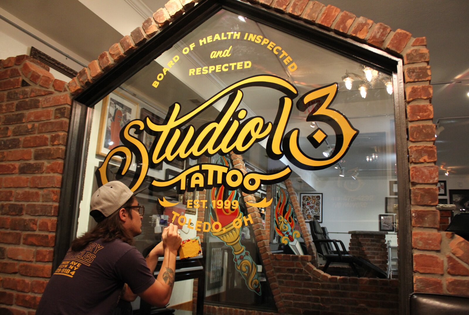 Sign painter Justin Lim works on painting at Studio 13 at their Toledo location.