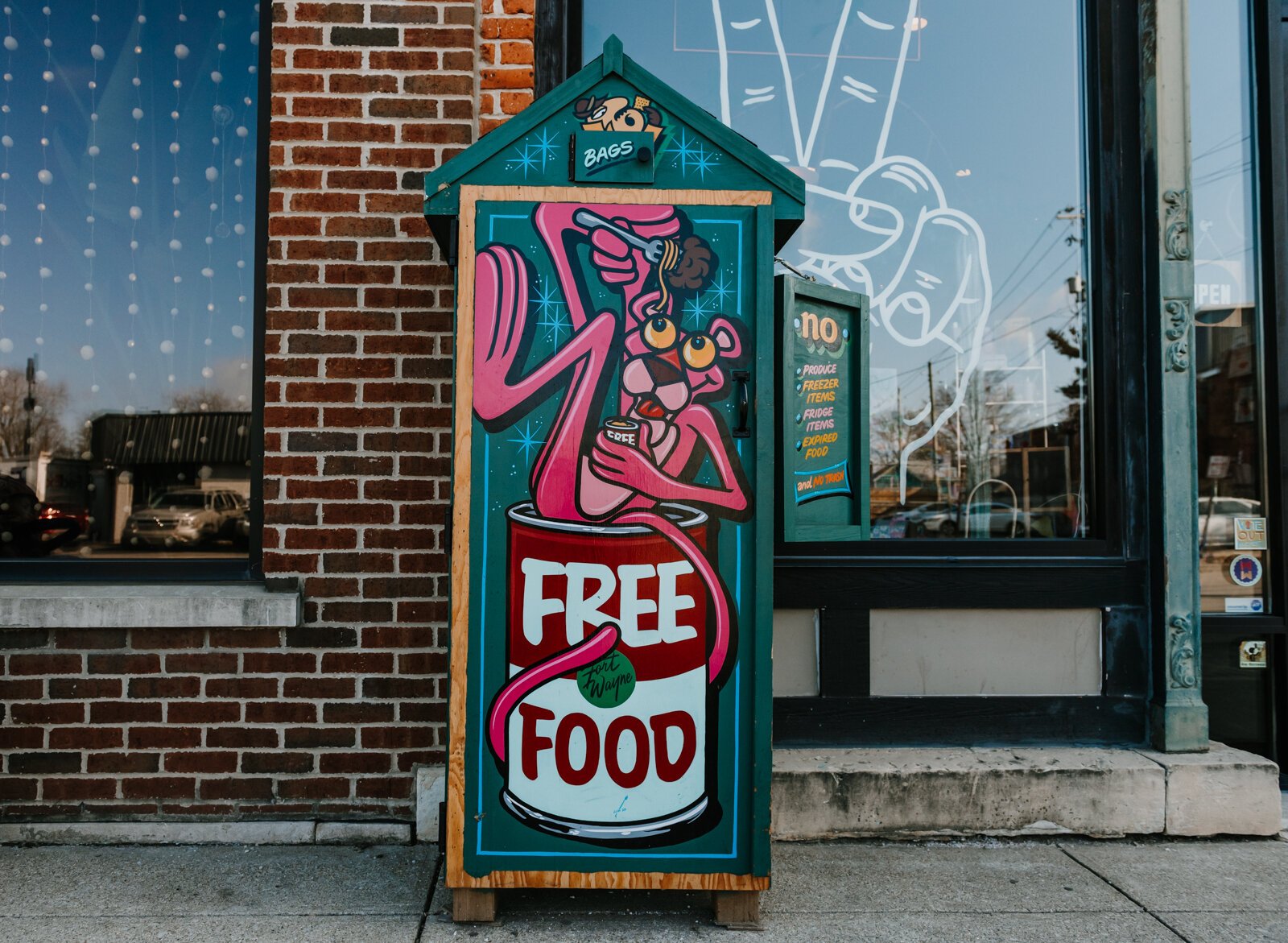 Justin Lim, owner of Old 5 and Dime Sign Co., hand painted the free food pantry in front of Fancy & Staple on Broadway in Fort Wayne, IN.