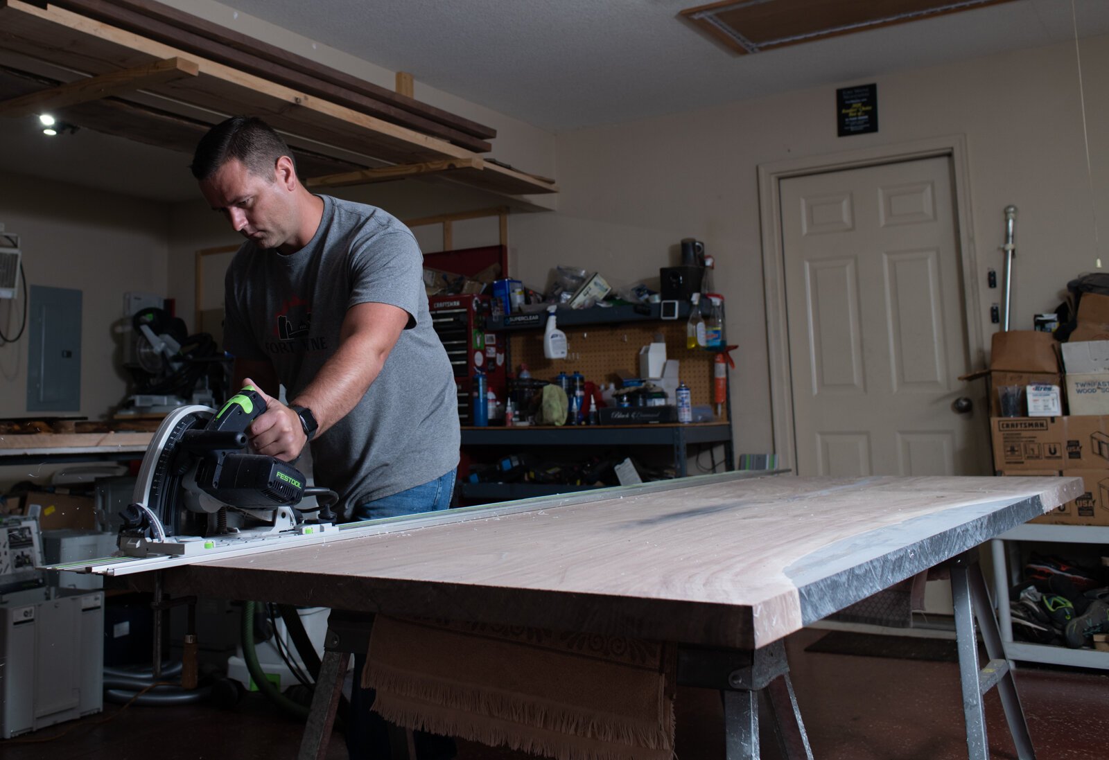 Lee Hoffmeier of Fort Wayne Industrial Revolution works on cutting a black walnut table to size for a client in Detroit in his home in Fort Wayne.