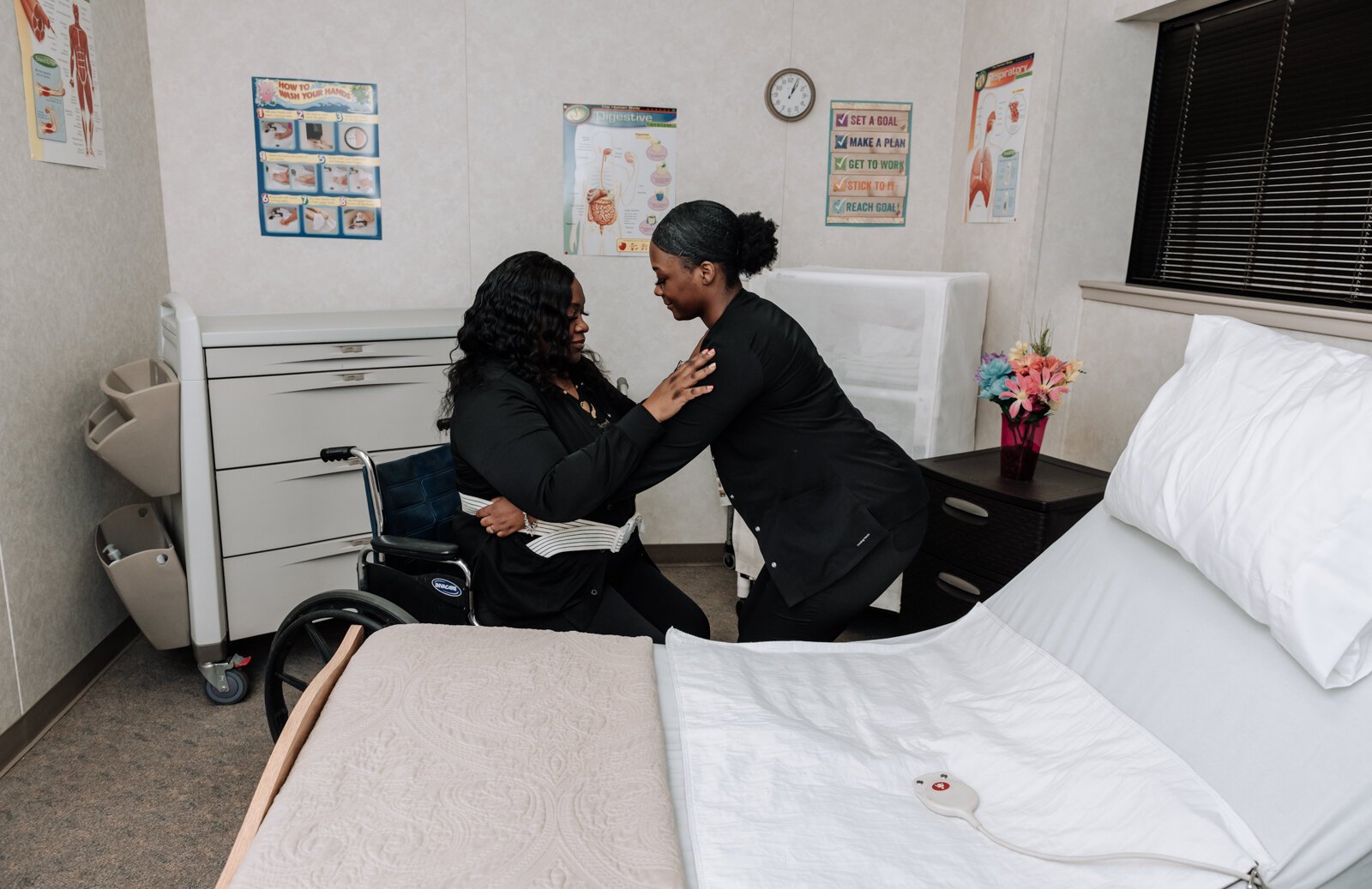 Student Ja'Lona Franklin, helps mother SeAndra Robinson RN CEO with a wheelchair assist while at Lifeline Academy.