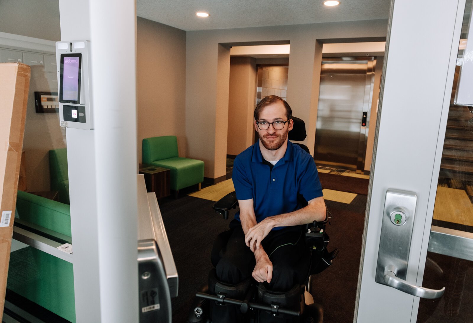 Luke Labas at the front of his apartment complex, which does not have automatic handicapped doors.