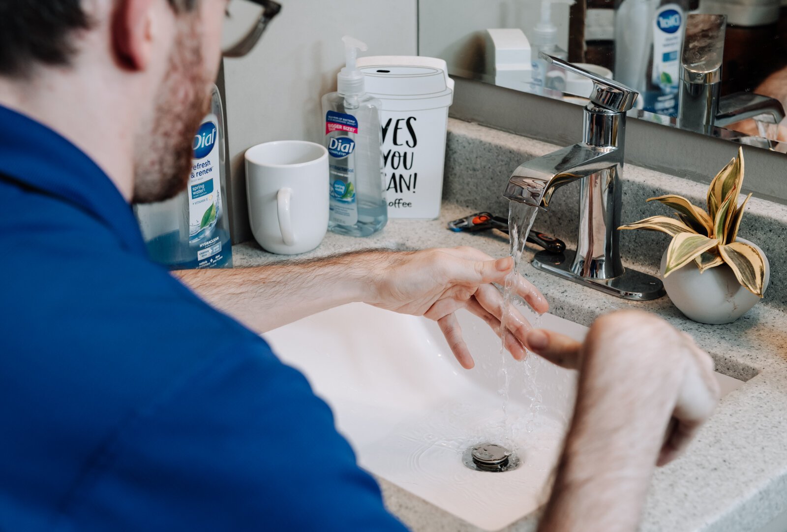 Luke Labas using the sink in an accessible bathroom in his apartment.