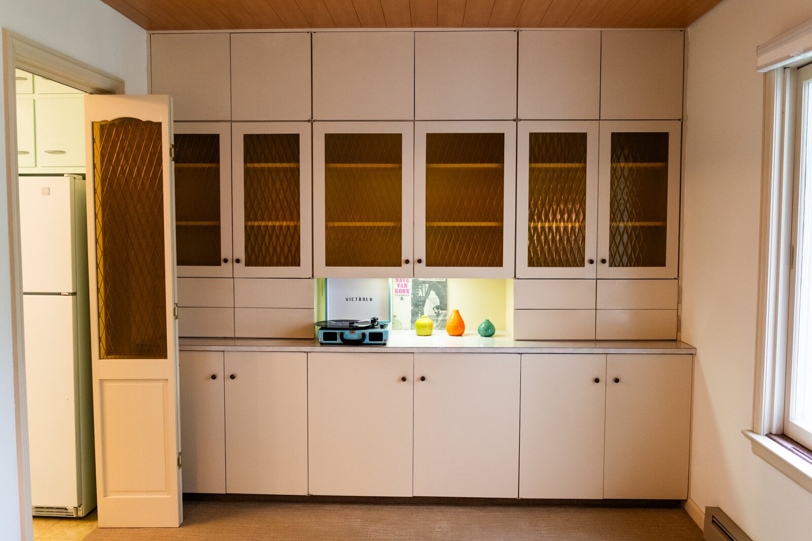 Plenty of storage along with a record player as the living room leads into the kitchen.