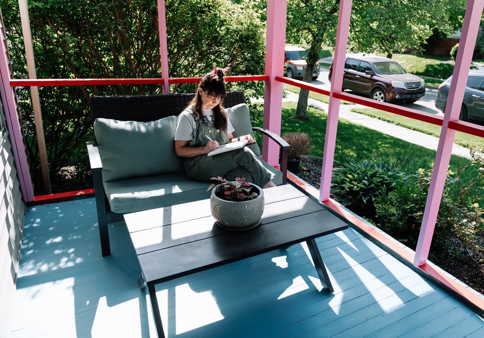 Sarah Wolfe, artist in residence, journals on the front porch while at 930 Illsley Drive.