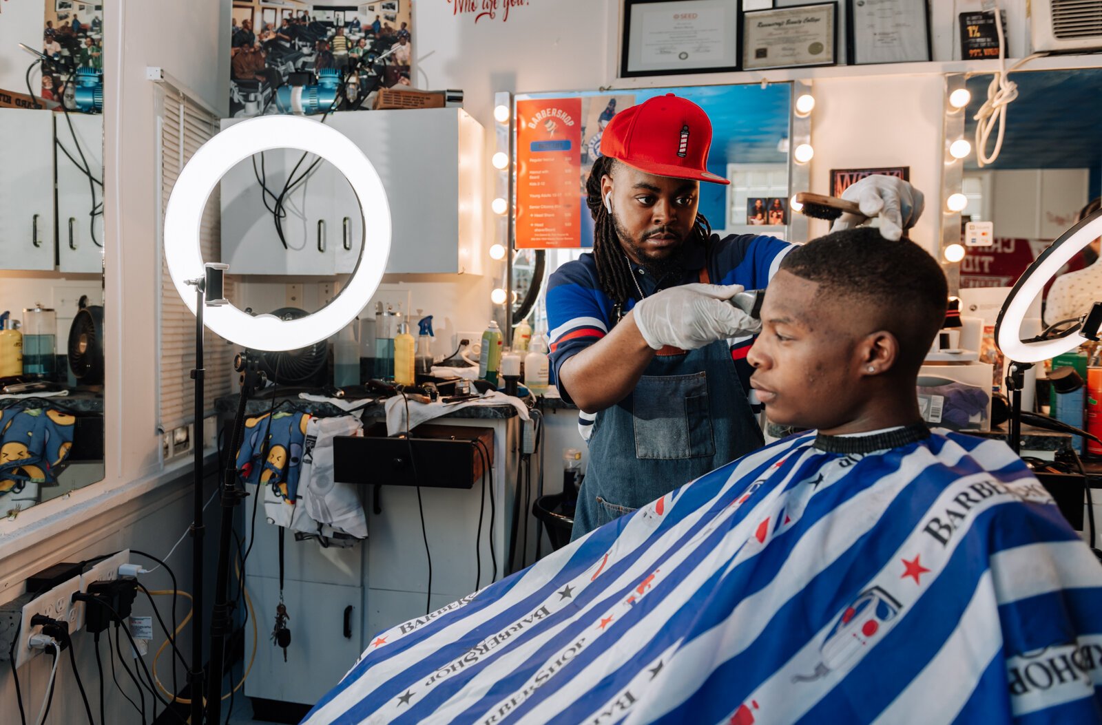 Barber Benson Harvey, owner of Smooth Kutz, works on giving Roderick Williams a bald fade.