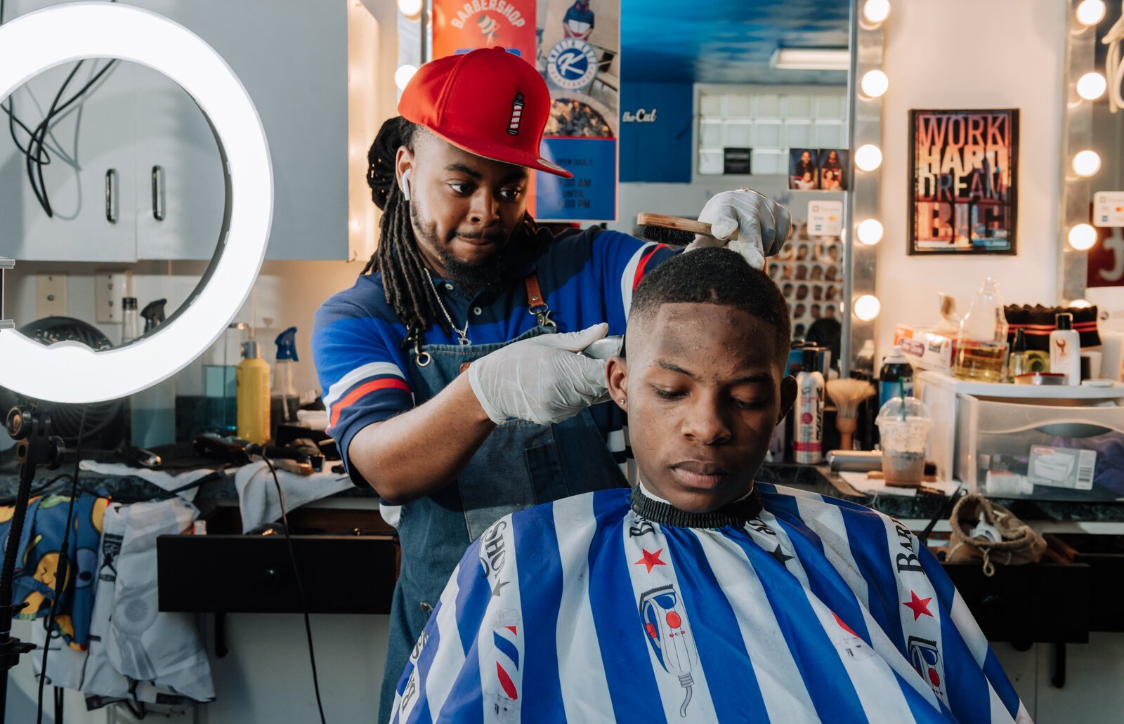 Barber Benson Harvey, owner of Smooth Kutz, works on giving Roderick Williams a bald fade.