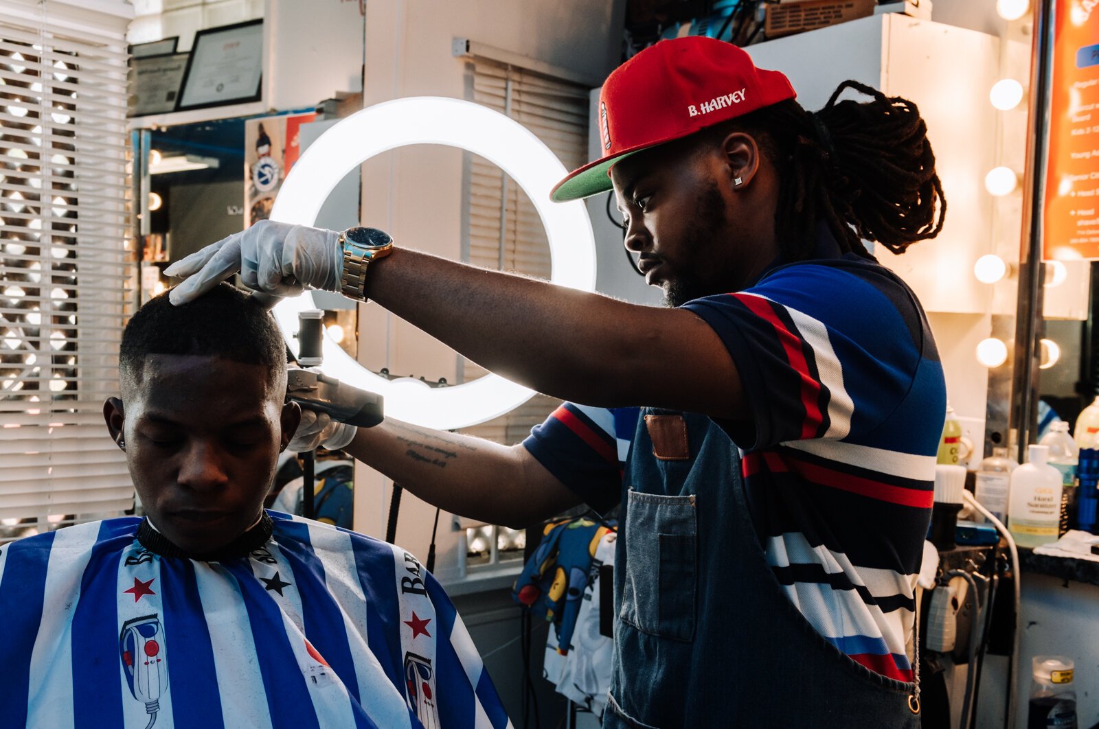 Barber Benson Harvey, owner of Smooth Kutz, works on giving Roderick Williams a bald fade.