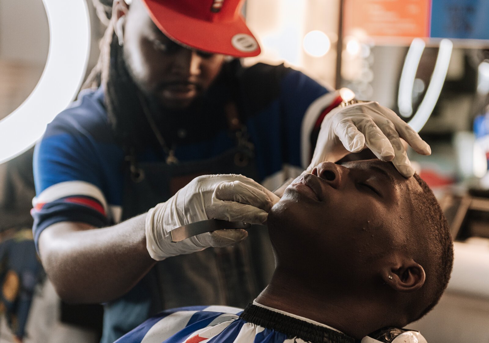 Barber Benson Harvey, owner of Smooth Kutz, works on giving Roderick Williams a bald fade.