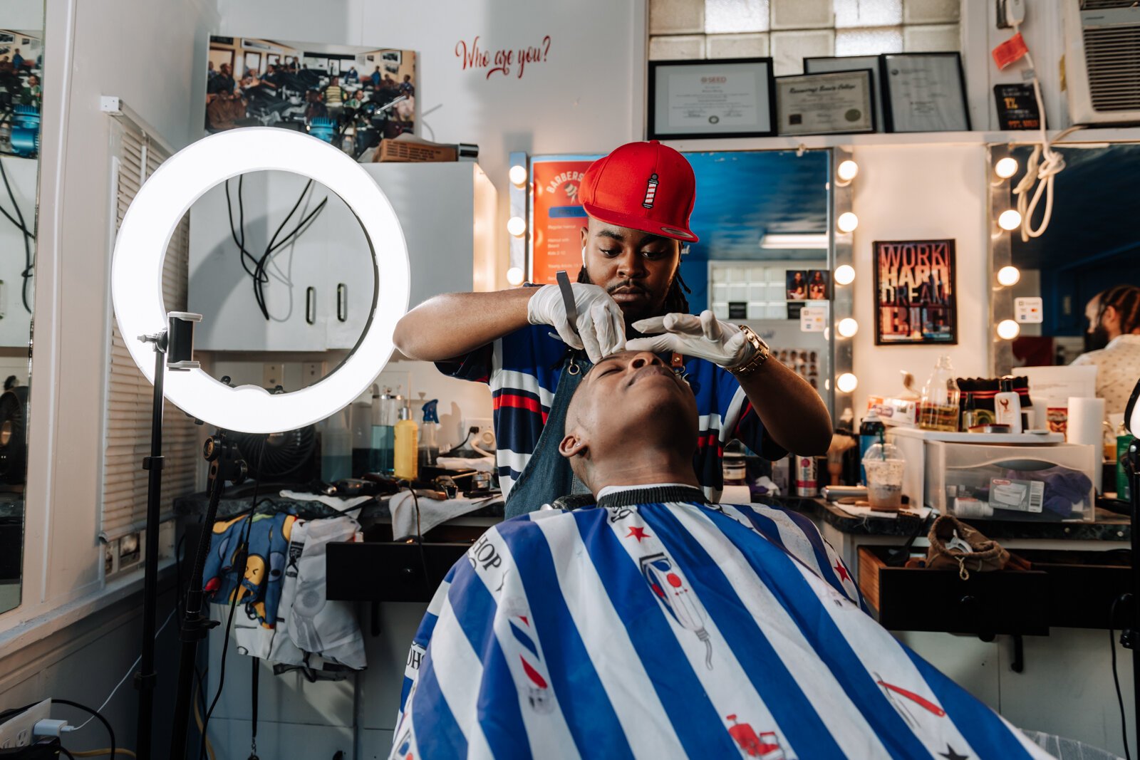 Barber Benson Harvey, owner of Smooth Kutz, works on giving Roderick Williams a bald fade.