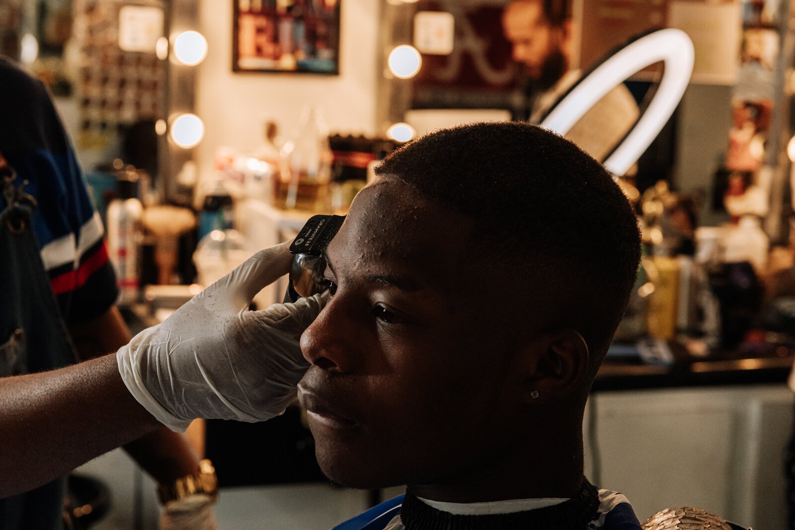 Barber Benson Harvey, owner of Smooth Kutz, works on giving Roderick Williams a bald fade.