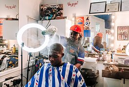 Barber Benson Harvey, owner of Smooth Kutz, works on giving Roderick Williams a bald fade.