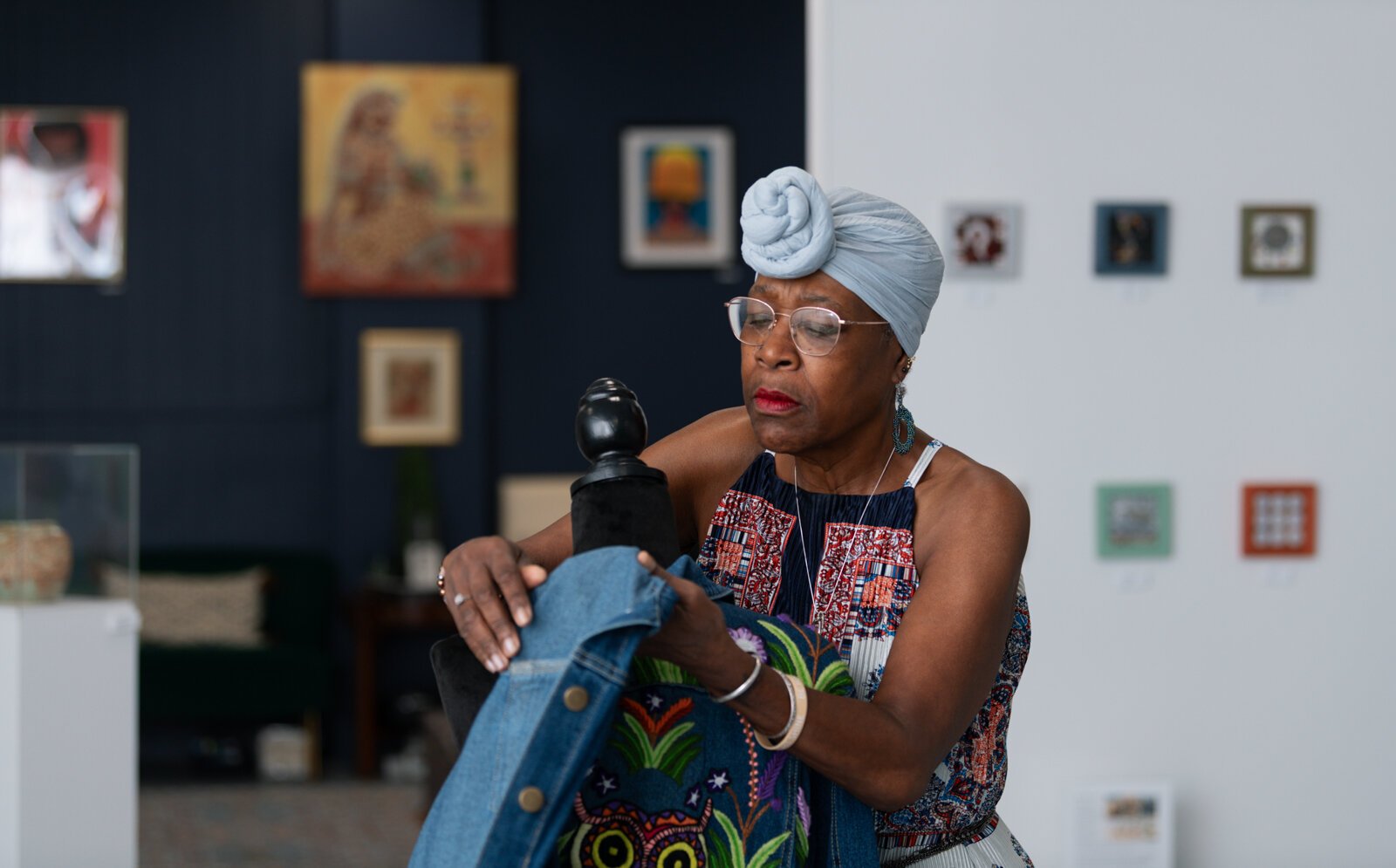 Owner of BIPOCA Incubator and Gallery Clydia Early straightens an "Owl Embroidery Jacket" by Ely Minnick.