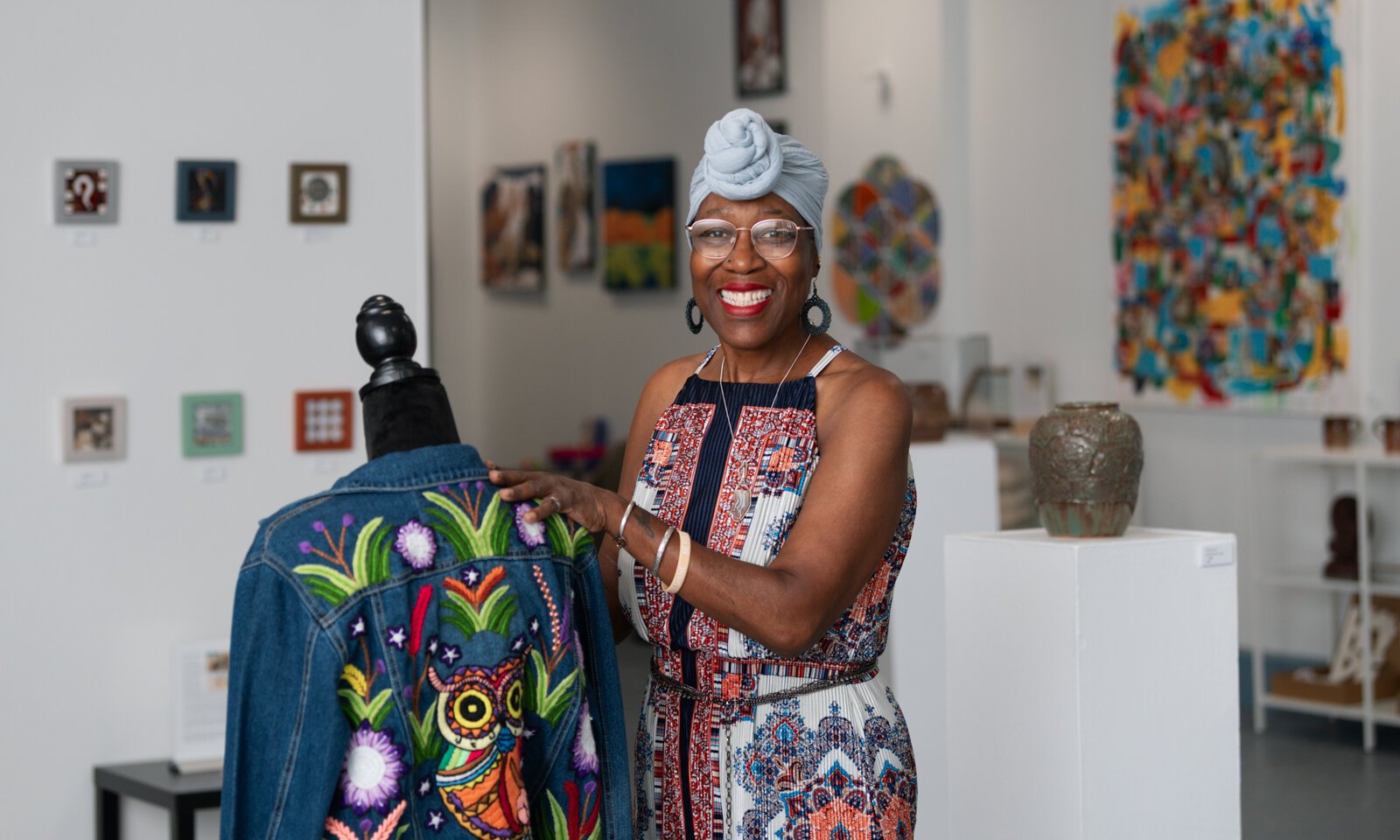 Owner of BIPOCA Incubator and Gallery Clydia Early straightens an "Owl Embroidery Jacket" by Ely Minnick.