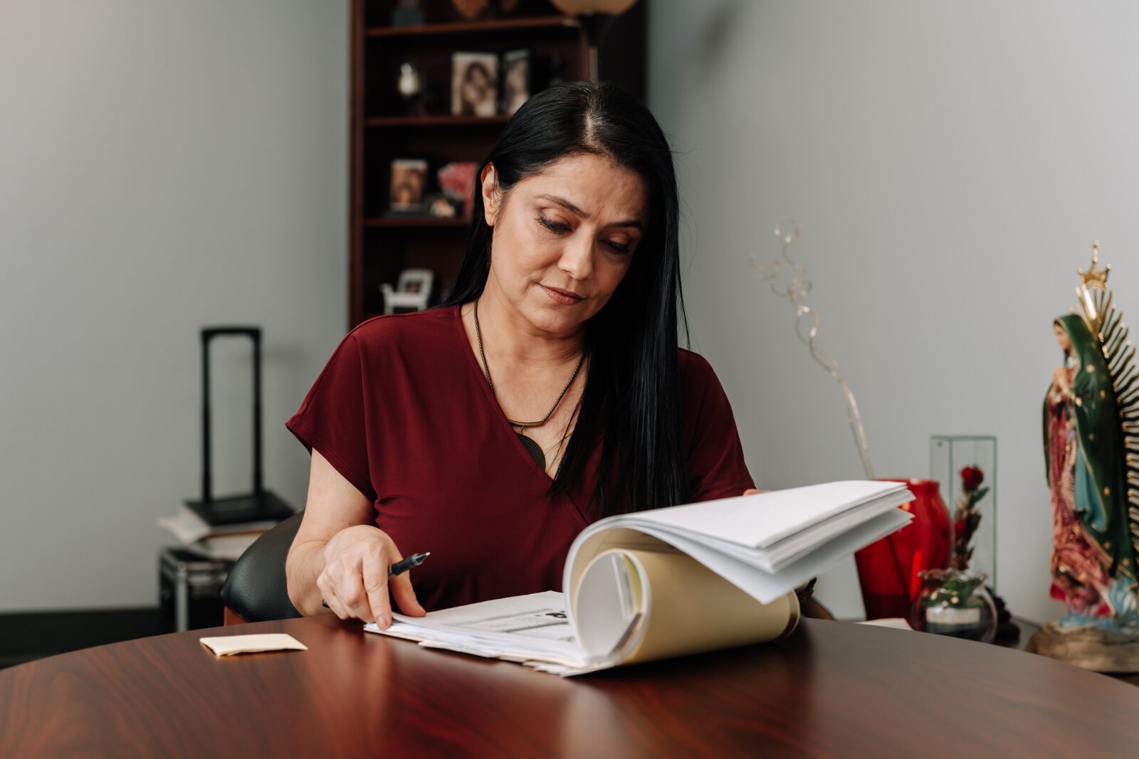 Luz Ostrognai with Catholic Charities works in her office at the Archbishop Noll Catholic Center.