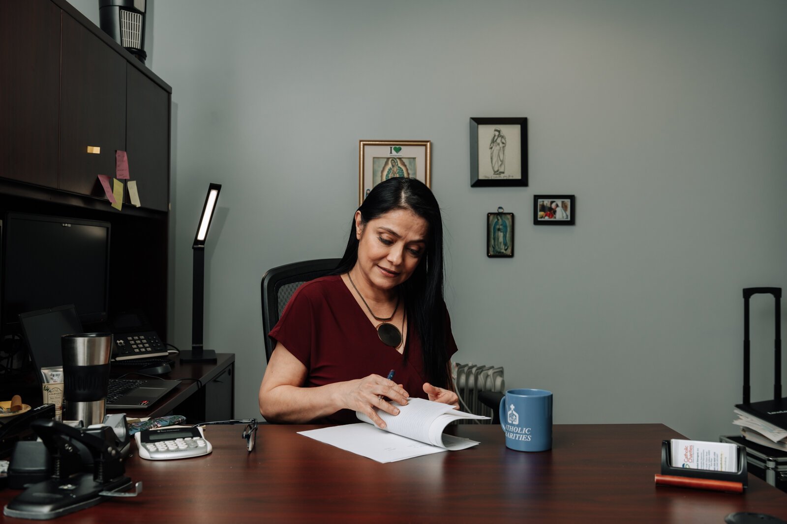 Luz Ostrognai with Catholic Charities works in her office at the Archbishop Noll Catholic Center.