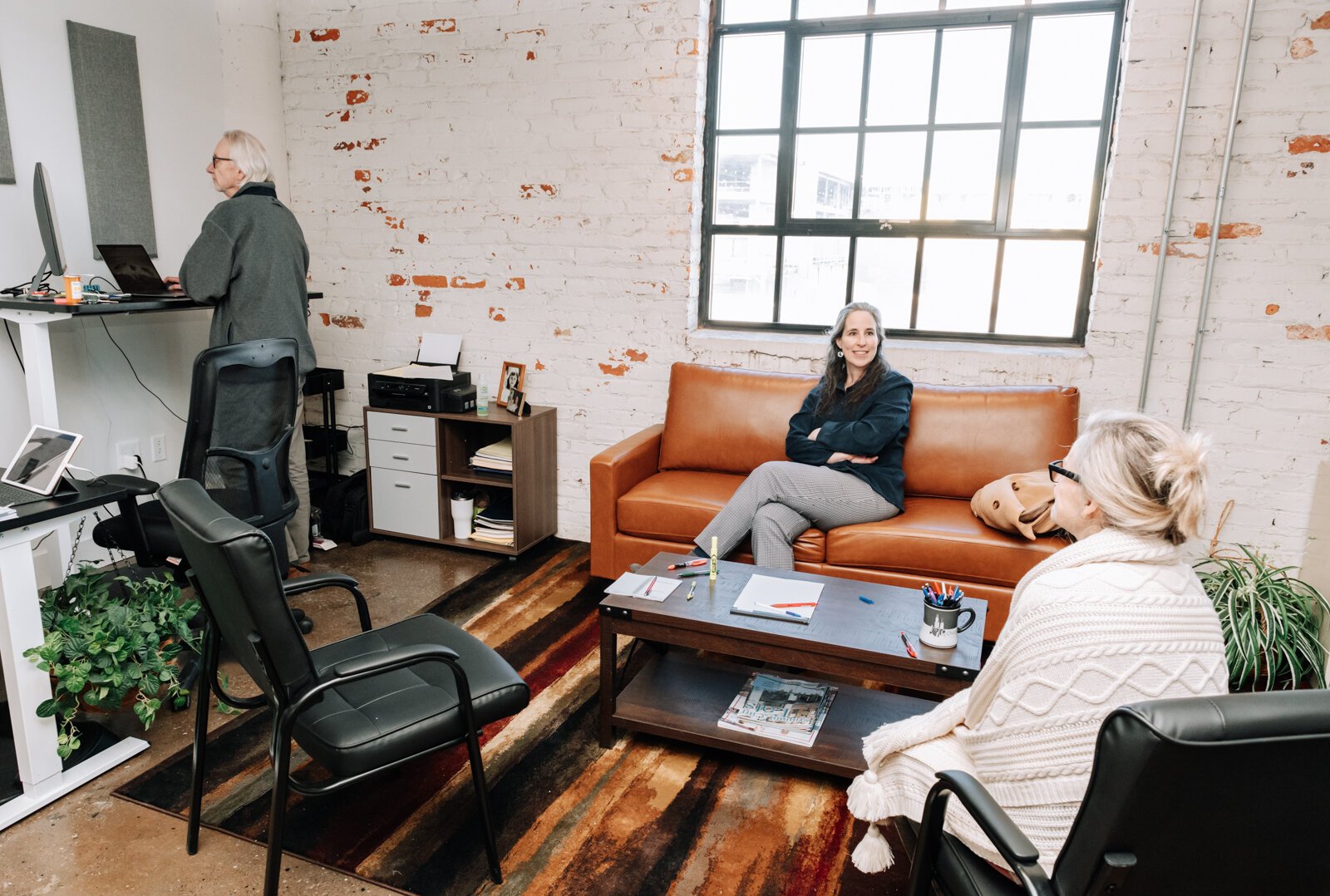 From left: Linda Valley, Debbie Lemmon, and Jeff Hartman with Master Consultants co work together in one of the offices at Paper Mill Workspace on the 4th floor above Utopian Coffee. 